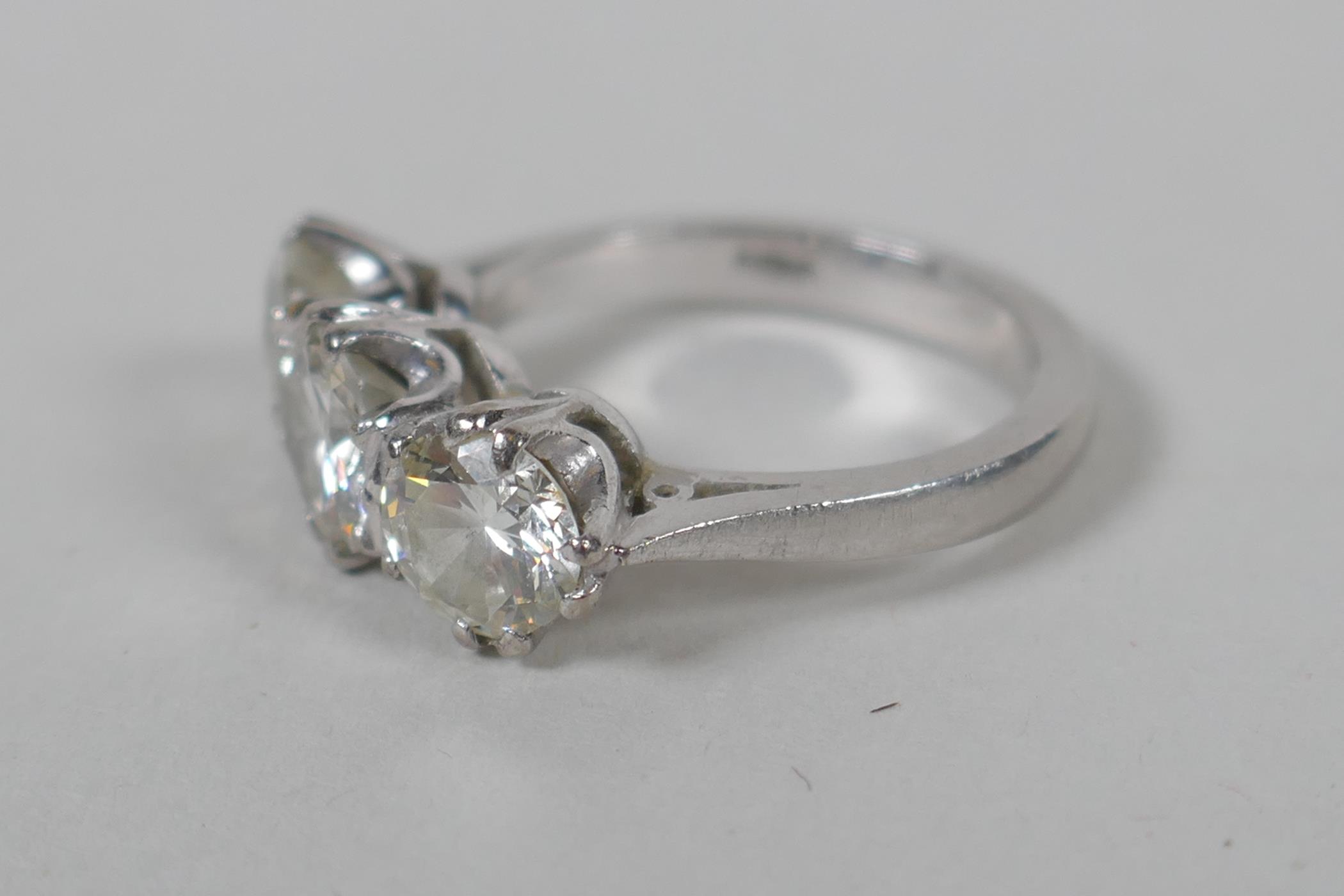 A platinum set three brilliant cut diamond ring, the central stone approx 0.95ct, flanking two - Image 4 of 8