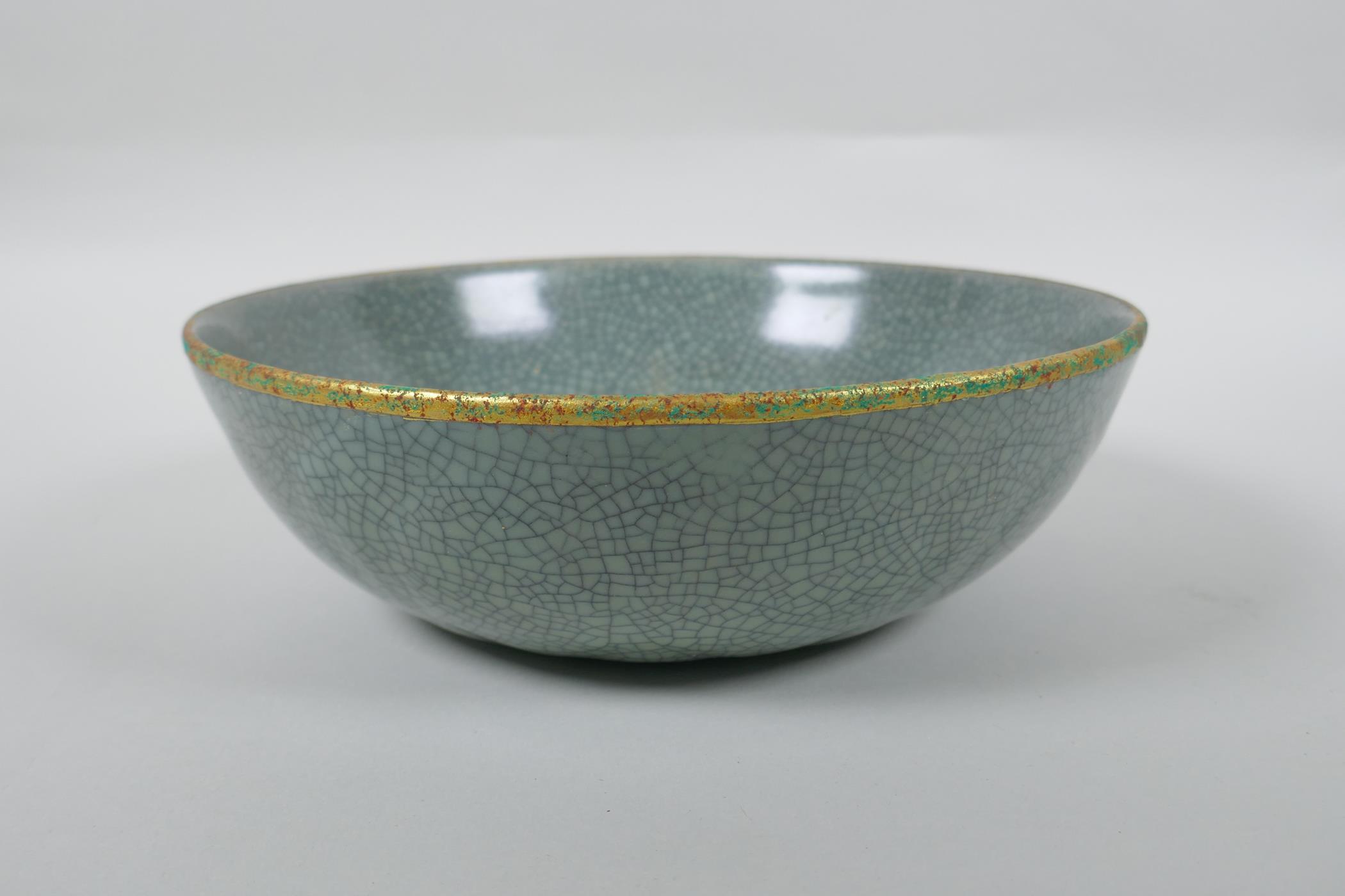 A Chinese celadon crackle glazed porcelain bowl with a gilt metal rim and decorated with chased - Image 2 of 5