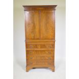 A mahogany tallboy cabinet with two cupboards over a brushing slide and four drawers, raised on