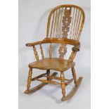 A yew wood hoopback rocking chair with pierced splat and elm seat