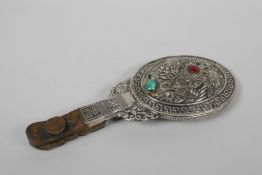 A Chinese white metal hand mirror with repousse dragon and phoenix decoration and a carved hardstone