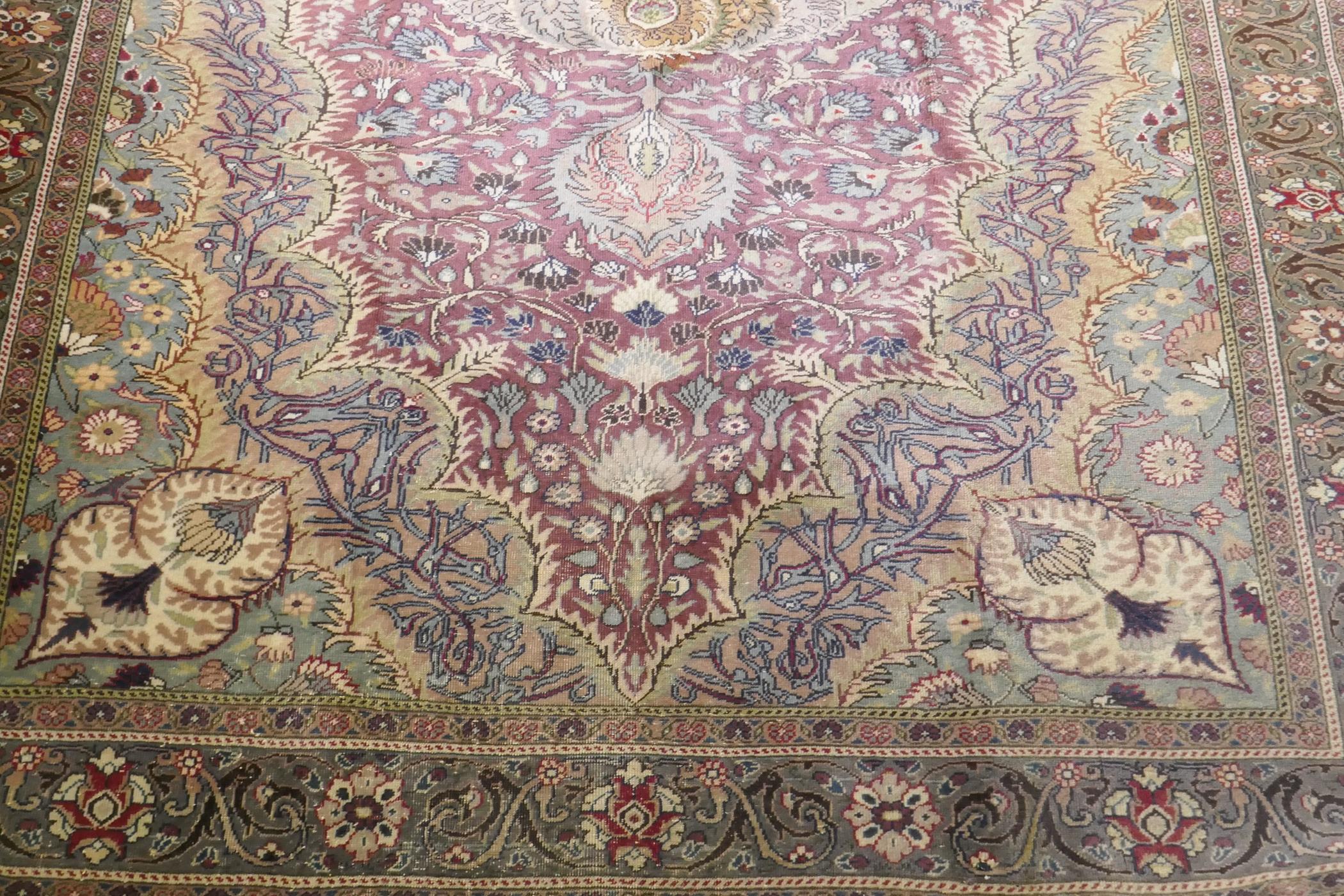 A Turkish Hereke wool carpet with central design on a faded terracotta field, with blue/grey - Image 3 of 8