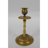 An unusual brass candlestick with Arabic inscription to the base and raised insect decoration,