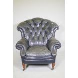 A Victorian style button back leather armchair, with scroll arms, fan back and studded detail,