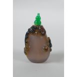 A Chinese agate snuff bottle with carved kylin and ruyi decoration, 6cm high
