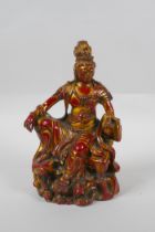 A Chinese bronze figure of Quan Yin with gilt and red lacquer patina, 21cm high