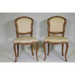 A pair of C19th French beechwood side chairs with carved decoration and brass stud detail