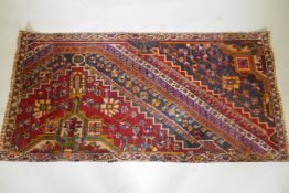 A Kashkai wool runner with geometric designs on a red field, 84 x 174