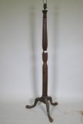 An antique mahogany standard lamp with carved reeded column and tripod supports, 145cm high