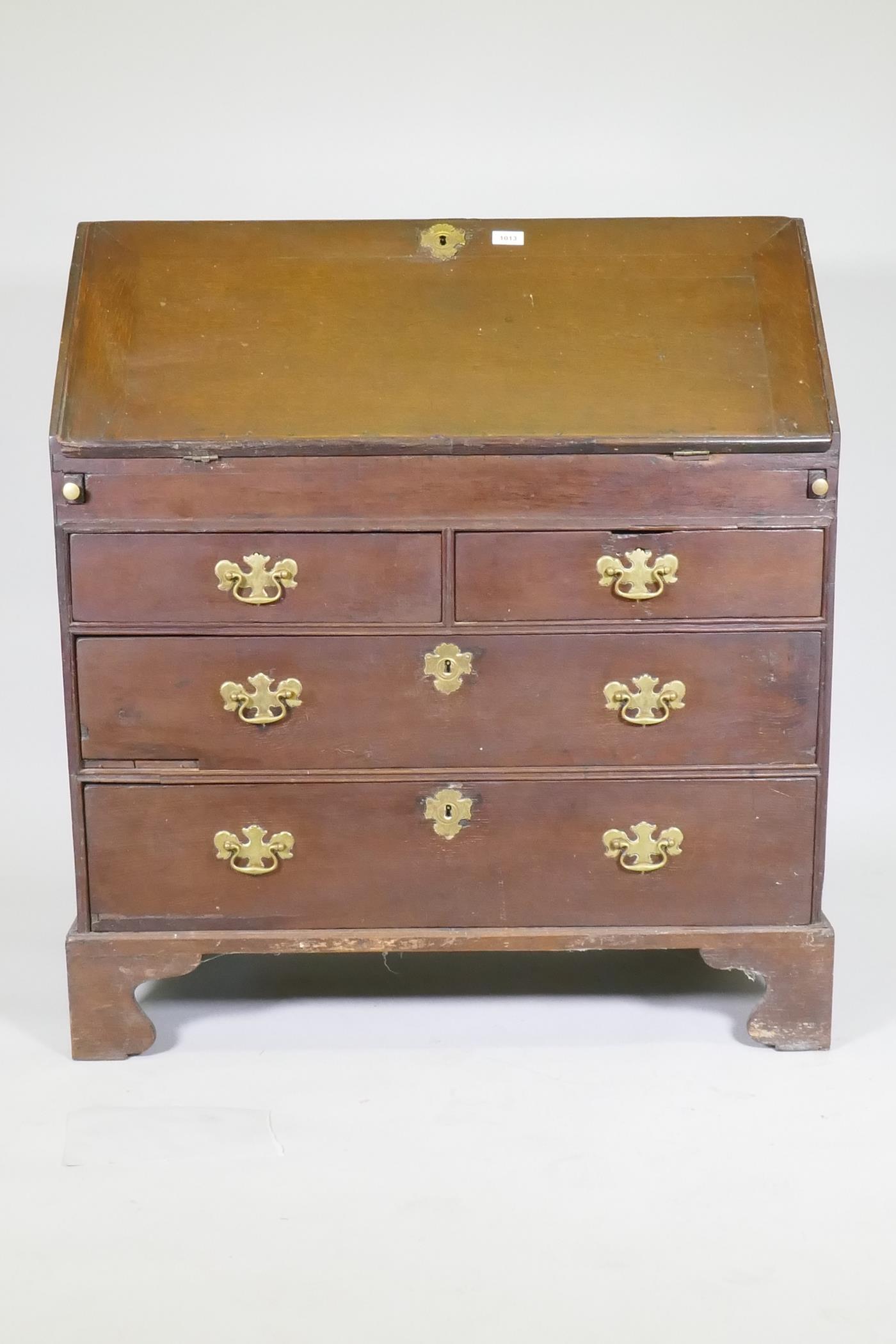 An early Georgian oak fall front bureau, the interior with drawers and pigeon holes and slide