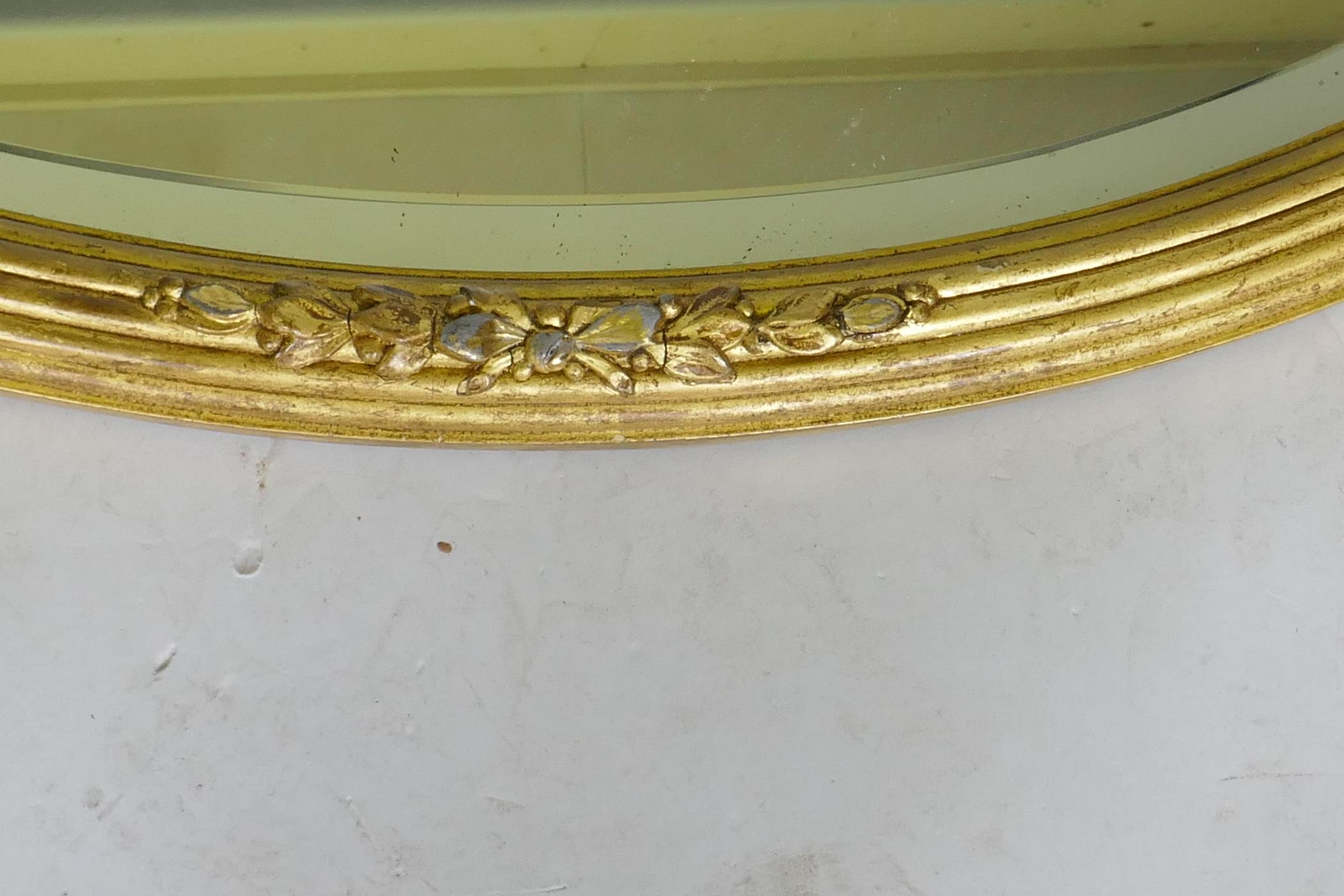 A gilt oval mirror with bevelled glass, AF losses, 82 x 60cm - Image 3 of 4