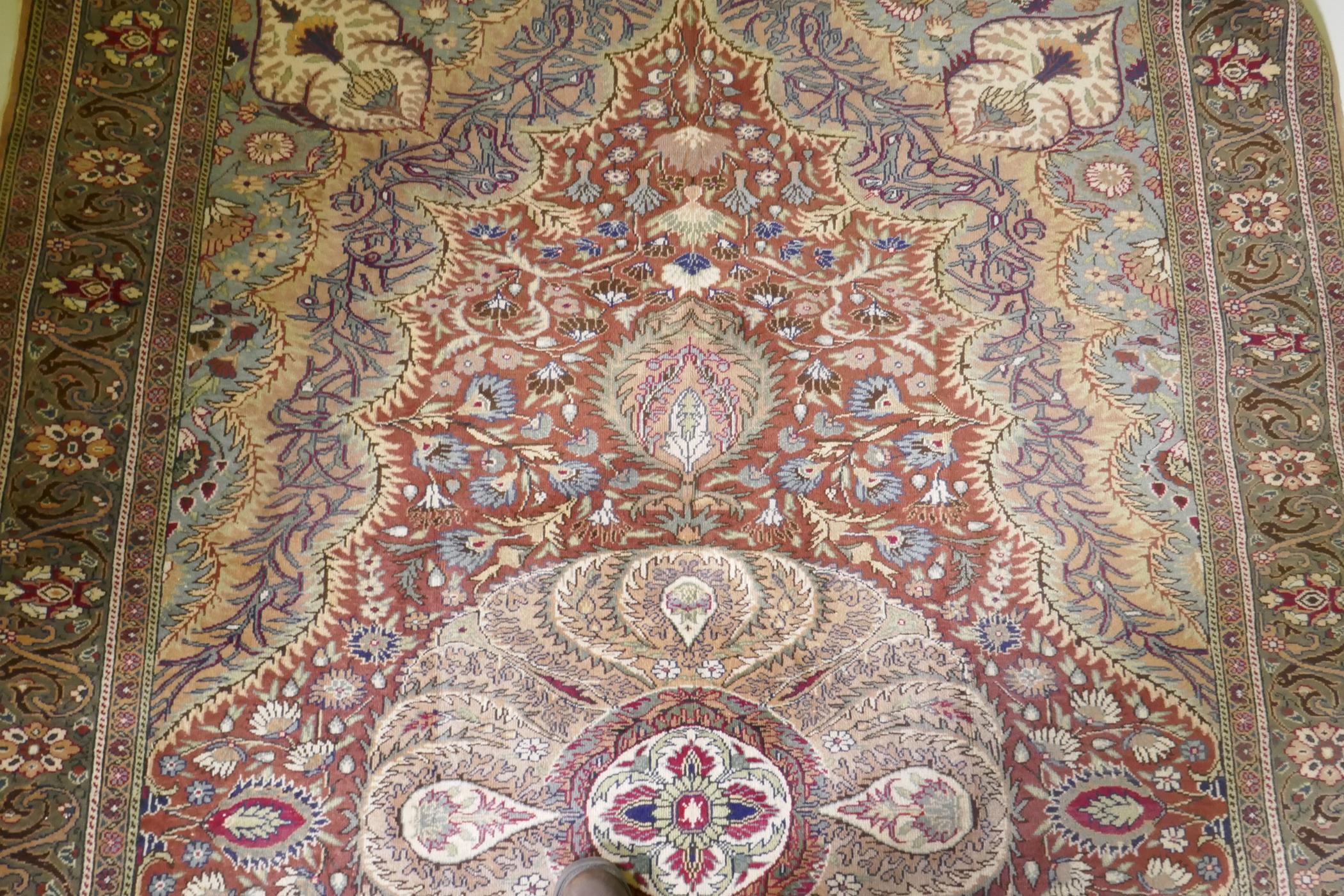 A Turkish Hereke wool carpet with central design on a faded terracotta field, with blue/grey - Image 5 of 8