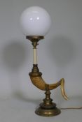 A table lamp in the form of a ram's horn, with brass mounts and opaline glass shade, 68cm high