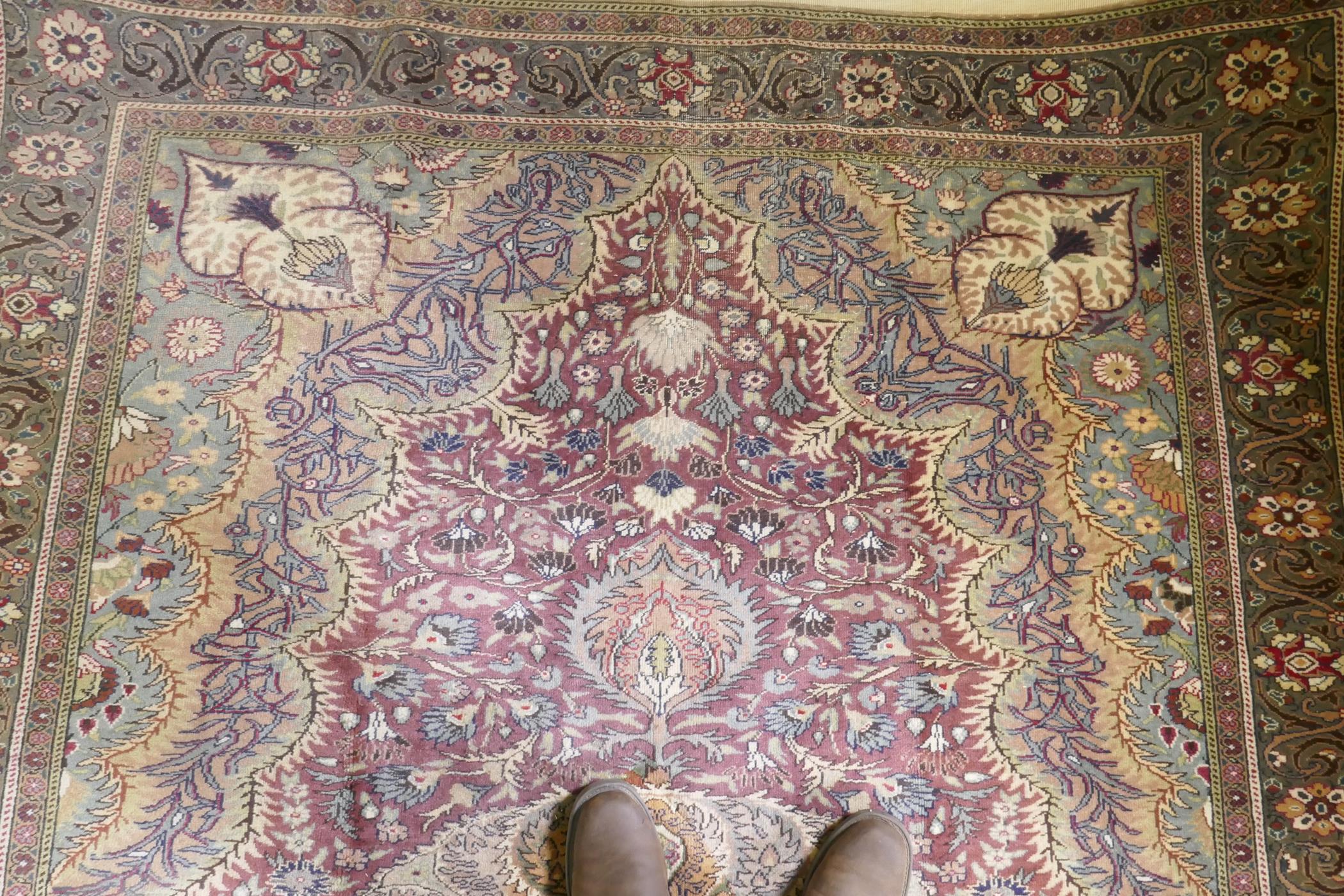 A Turkish Hereke wool carpet with central design on a faded terracotta field, with blue/grey - Image 7 of 8