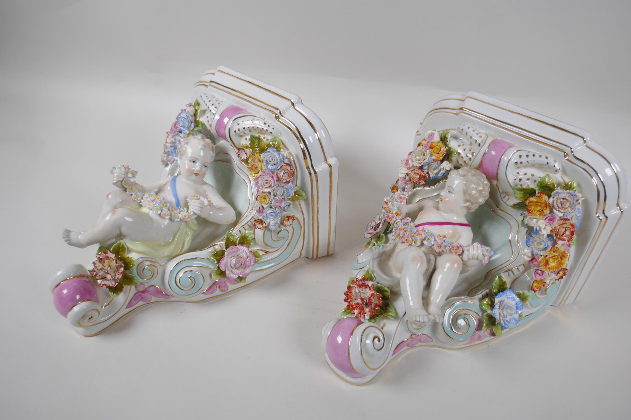 A pair of Dresden style porcelain wall brackets decorated with putti and flowers, 24cm high - Image 2 of 4