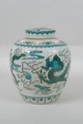 A Chinese porcelain ginger jar and cover, decorated with emerald green dragons, chasing the