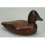A carved and stained wooden decoy duck,