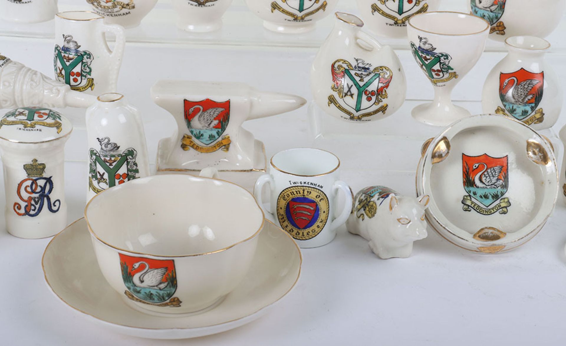 A quantity of crested china, including longcase clocks, cups, animals