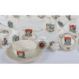 A quantity of crested china, including longcase clocks, cups, animals