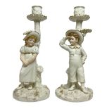 Pair of Royal Worcester figural candlesticks designed by James Hadley in the style of Kate Greenaway