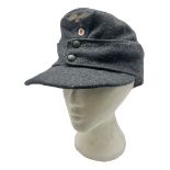 WW2 German Luftwaffe M43 field cap with triangular cloth eagle and roundel badge; marked '1944 ?/050