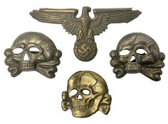 Two WW2 German 'SS' visor cap skull badges and another later; and visor cap eagle insignia (4)