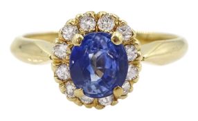 Gold oval sapphire and round brilliant cut diamond cluster ring