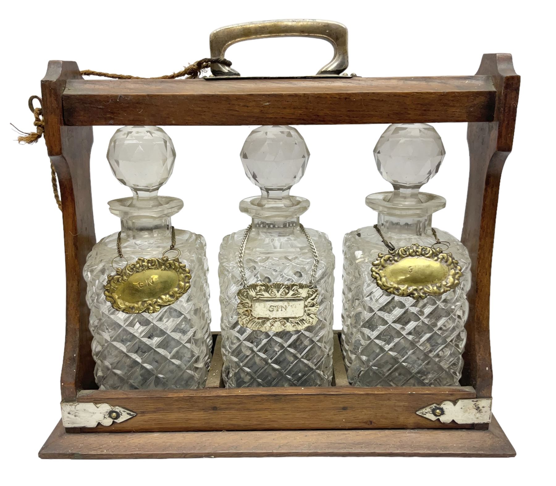 Edwardian oak tantalus with silver plated mounts with three square sided glass decanters