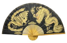 Chinese fan of large proportion decorated with gilt dragons on black ground