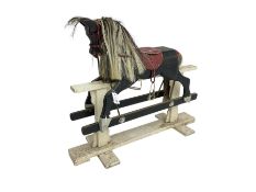 20th century black painted rocking horse on white painted trestle base