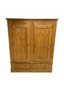 Large solid pine double wardrobe enclosed by two panelled doors over two drawers