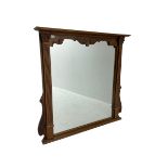 Carved and stained beech overmantle mirror with projecting cornice above square plate