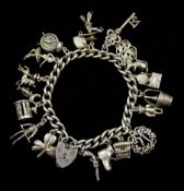 Silver charm bracelet with heart padlock clasp and eighteen silver charms including alarm clock