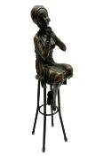 Art Deco style bronze figure of a lady seated on a stool applying lipstick