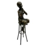 Art Deco style bronze figure of a lady seated on a stool applying lipstick