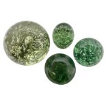 Four Victorian and later green glass dump paperweights with with air bubble inclusions