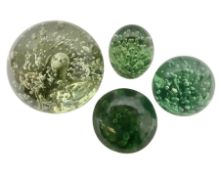 Four Victorian and later green glass dump paperweights with with air bubble inclusions