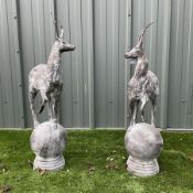 A pair of cast iron garden stag finials on ball bases