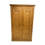 Solid pine double wardrobe enclosed by two panelled doors