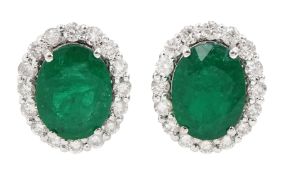 Pair of 18ct white gold oval emerald and round brilliant cut diamond cluster stud earrings