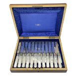 Cased set of twelve Walker & Hall mother of pearl handled knives and forks housed in blue silk lined