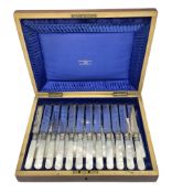 Cased set of twelve Walker & Hall mother of pearl handled knives and forks housed in blue silk lined