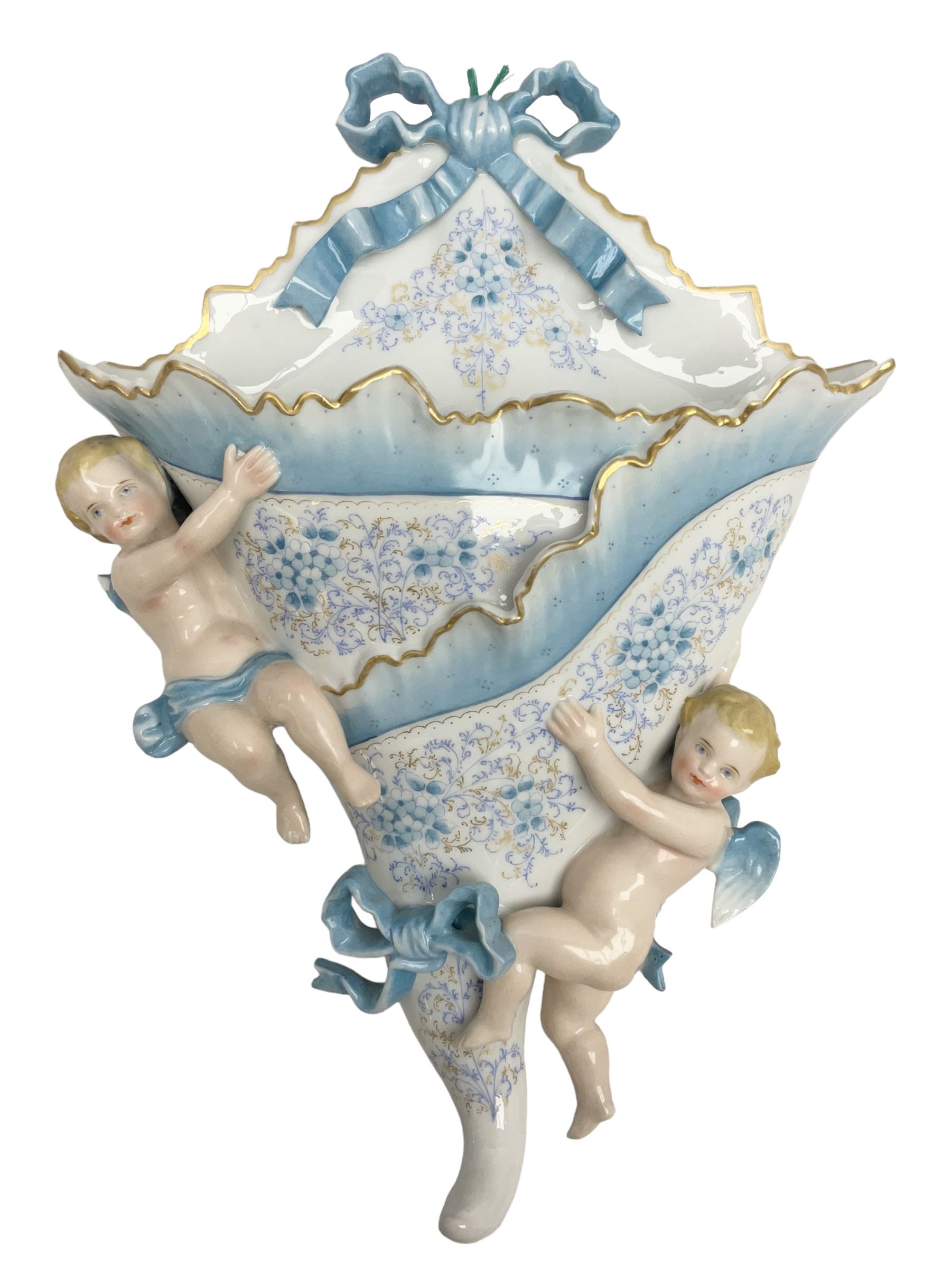 Continental wall pocket applied with two putti and ribbons and decorated with blue and gilt flowers