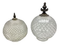 Two clear glass light shades of globular form with foliate metal mounts