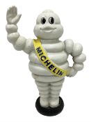 Cast iron money bank of a waving Michelin man stood on a tyre