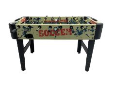 Sportcraft table football game raised on supports with stretcher