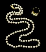 Gold three stone pearl ring and a single strand pearl necklace