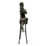 Art Deco style bronze figure of a lady seated on a stool applying lipstick