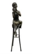 Art Deco style bronze figure of a lady seated on a stool applying lipstick