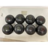 Eight lawn green bowling balls